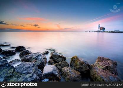 The Horse of Marken lighthouse (Het Paard van Marken) during sunrise. Marken is a small fishing village on the coast of the IJsselmeer in The Netherlands. Lighthouse on the Dutch coast near the island of &rsquo;marken&rsquo; during sunrise on a large inland lake