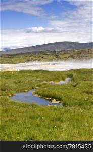 The hot springs and oasis on the Kjolur Highland route in Iceland at Hveravellir. The vatnajokull glacier is visible in the distance