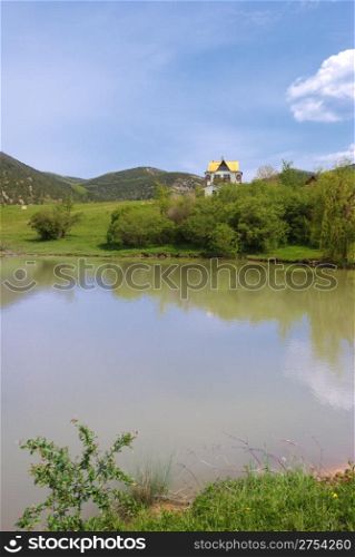 The house at lake. A cottage located in a valley, surrounded by mountains