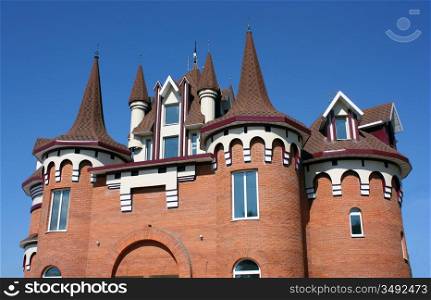 The house with a beautiful roof with windows and carved domes from a red brick.