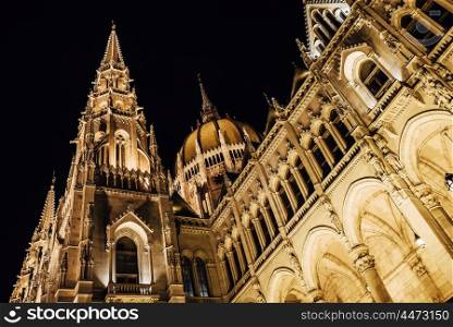 The Hungarian Parliament in Budapest on the Danube in the night lights of the street lamps