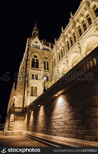 The Hungarian Parliament in Budapest on the Danube in the night lights of the street lamps