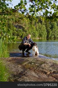 The hunter and his English Springer Spaniel puppy on the shore