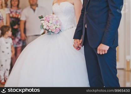 The husband and wife hold tight to the hand.. Newlyweds hold hands tightly at the wedding ceremony 2447.