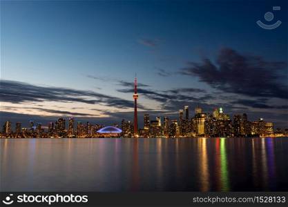The illuminated Toronto skyline with Lake Ontario in the foreground, as seen from Center Island.