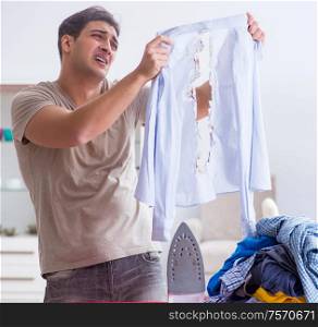 The inattentive husband burning clothing while ironing. Inattentive husband burning clothing while ironing