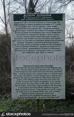 The information plate or table in bulgarian and english language for ancient history of the Demir Baba Teke, cult monument honored by both Christians and Muslims in winter near Sveshtari village, Municipality Isperih, Razgrad District, Northeastern Bulgaria