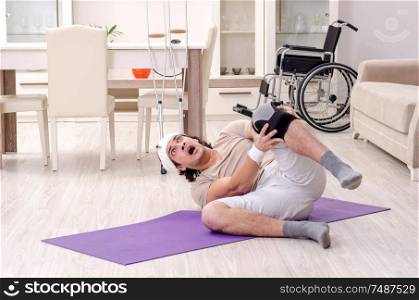 The injured young man doing exercises at home. Injured young man doing exercises at home