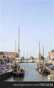 The inner harbor of Volendam, with old fishing boats moored along the quay and a draw bridge in the far end of the canal