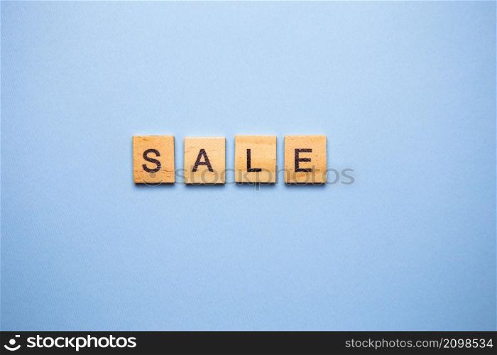 The inscription in English SALE on a blue background. Sale in online stores. Holiday sales, seasonal sales, Black Friday, Christmas, discounts and shopping on site. The inscription in English SALE on a blue background. Sale in online stores. Holiday sales, seasonal sales, Black Friday, Christmas, discounts and shopping on site.