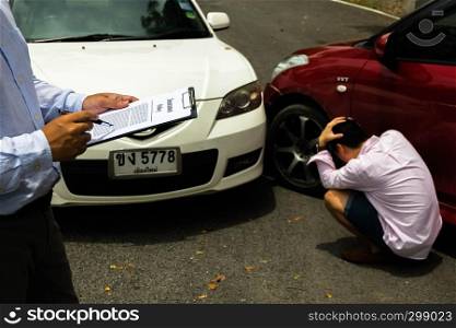The insurance agent examining car after accident on the road. Insurance claim concept .