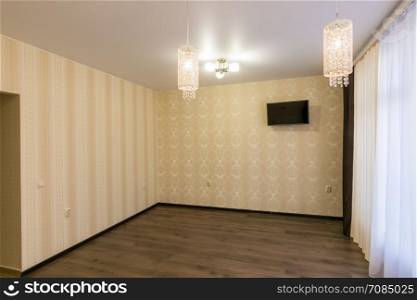 The interior of an empty renovated room, hangs on the wall TV