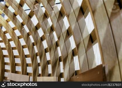 The Interior of Curved Diagonal Lines are made of the Wooden Composite with the Facade Design Architecture. Structure Perspective View of Softwood Curved Pergola. Sawn Arches, Design Architecture, Selective focus.
