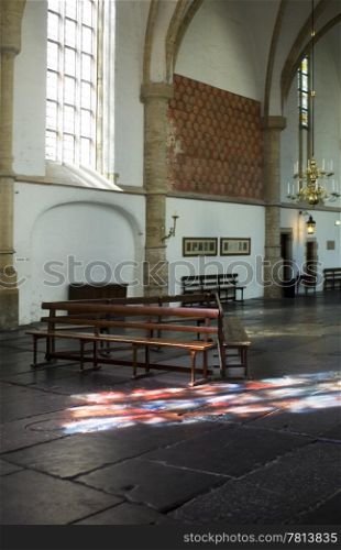 The interior of the Bavo Protestant Church in Haarlem, the Netherlands, with light cast through a stained window on the church floor