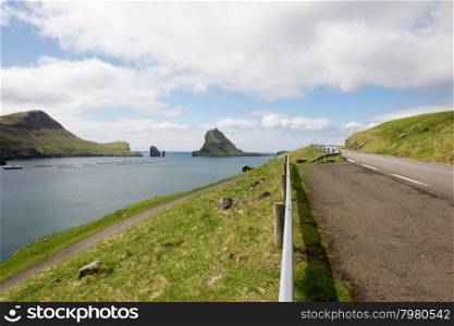 The island Gasholmur on the Faroe Islands. The island Gasholmur on the Faroe Islands with salmon farm as seen from a street on vagar