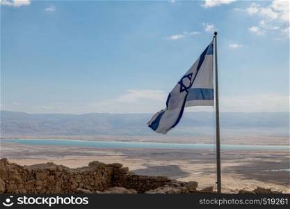 the israelian flag with the dead sea as background, seen from masada. the flag of israel at the dead sea