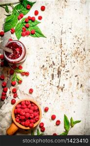 The jam with raspberries and mint leaves. On rustic background .. The jam with raspberries and mint leaves.
