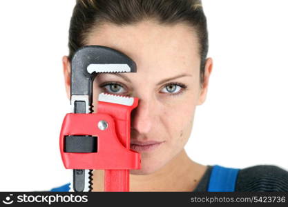 The jaw of a pipe wrench framing a woman&rsquo;s eye