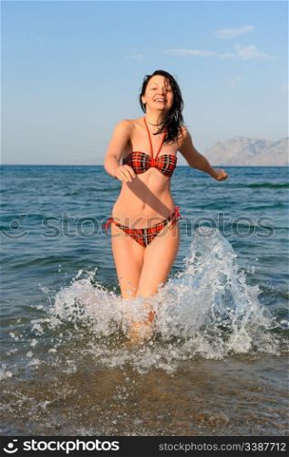 The joyful woman runs on sea water