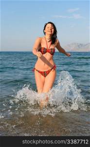 The joyful woman runs on sea water