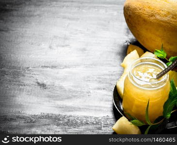 The juice from the melon with the mint leaves. On the black wooden table.. The juice from the melon with the mint leaves.