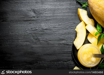 The juice from the melon with the mint leaves. On the black wooden table.. The juice from the melon with the mint leaves.