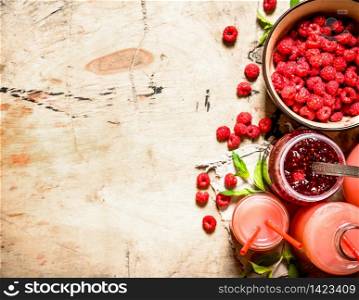 The juice of fresh raspberries and jam. On a wooden table.. The juice of fresh raspberries and jam.