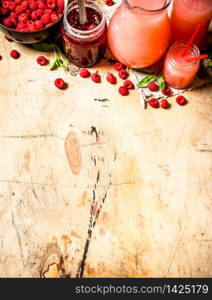 The juice of fresh raspberries and jam. On a wooden table.. The juice of fresh raspberries and jam.