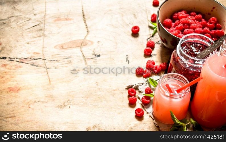 The juice of fresh raspberries and jam. On a wooden table.. The juice of fresh raspberries and jam.