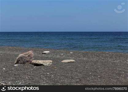 The Kamari beach with black volcanic stones at Santorini island, Greece