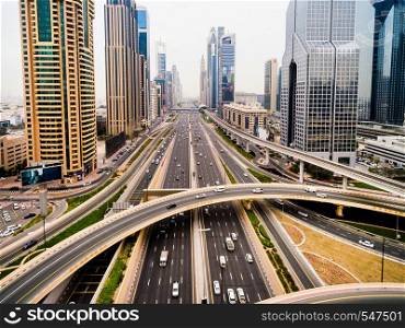 the landscape displays the traits of a modern metropolis with its fast movement.. beautiful aerial view of futuristic city landscape with roads, cars and skyscrapers. Dubai, UAE