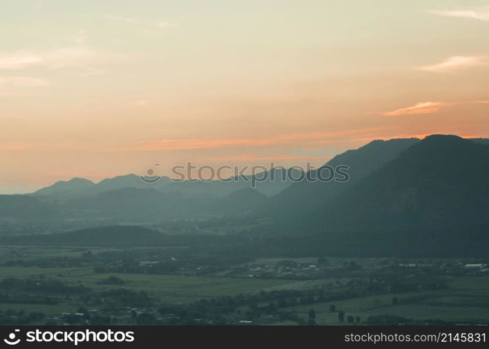 The landscape of green rice fields with the evening light of the sun contrasting with the sky.