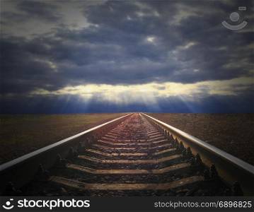 the landscape with dark evening clouds and rails going away. rails going away into the gloomy landscape. the landscape with dark evening clouds and rails going away