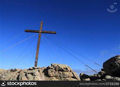 The large wooden cross at the top of Capu di a Veta behind the citadel town of Calvi in the Balagne region of Corsica