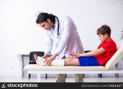 The leg injured boy visiting young doctor traumatologist. Leg injured boy visiting young doctor traumatologist