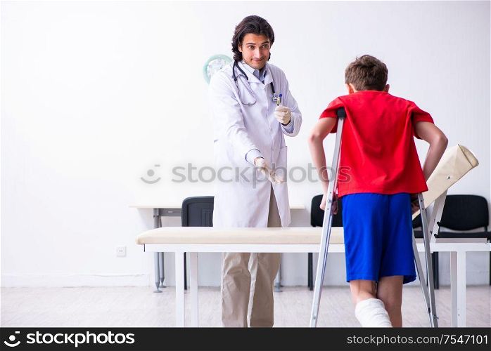 The leg injured boy visiting young doctor traumatologist. Leg injured boy visiting young doctor traumatologist