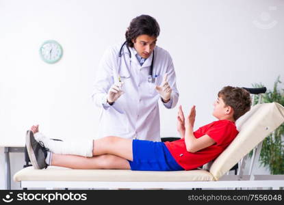 The leg injured boy visiting young doctor traumatologist. Leg injured boy visiting young doctor traumatologist