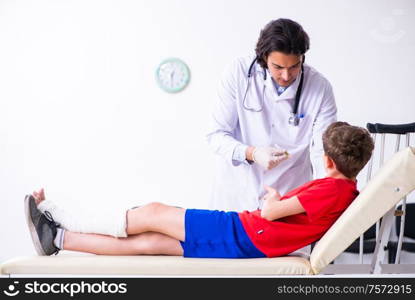 The leg injured boy visiting young doctor traumatologist. Leg injured boy visiting young doctor traumatologist