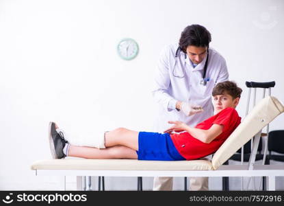 The leg injured boy visiting young doctor traumatologist. Leg injured boy visiting young doctor traumatologist