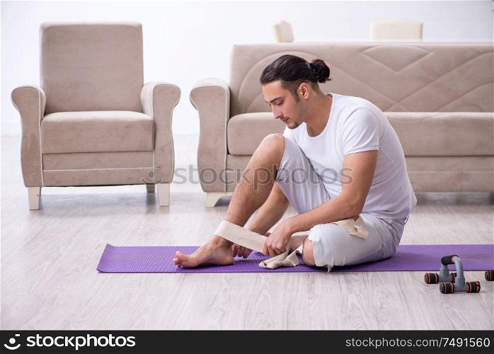 The leg injured man doing exercises at home. Leg injured man doing exercises at home