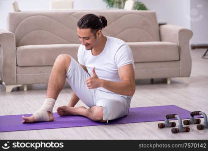 The leg injured man doing exercises at home. Leg injured man doing exercises at home