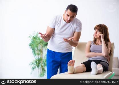 The leg injured woman visiting young doctor traumatologist. Leg injured woman visiting young doctor traumatologist