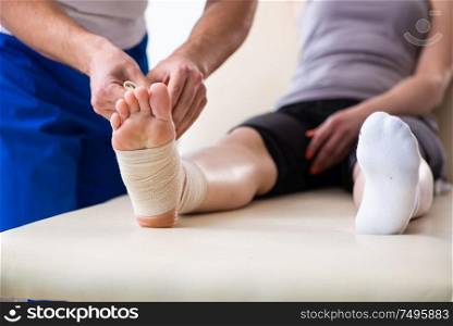 The leg injured woman visiting young doctor traumatologist. Leg injured woman visiting young doctor traumatologist