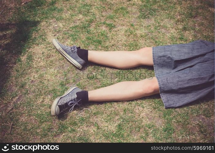 The legs of a young woman as she is relaxing on the grass in the summer