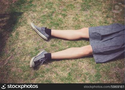 The legs of a young woman as she is relaxing on the grass in the summer