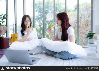 The LGBT couple celebrating with a glass of wine In a hotel room surrounded by nature