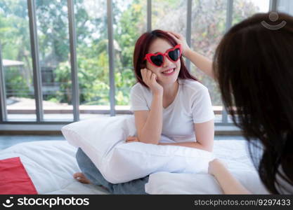 The LGBT couple trying on fashion glasses together as they arrive in hotel room to prepare for nature tourism in the countryside