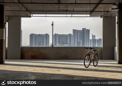 The light and shadow of evening pass through the pillars and Mountain bike in the empty parking lot. No focus, specifically.