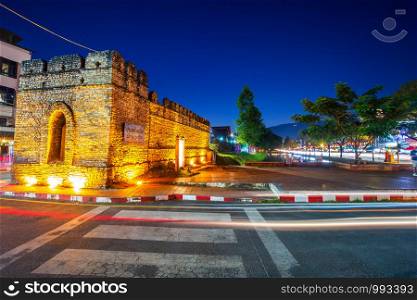 the light trails on the street at Chiang Mai Gate old city ancient wall and moat (chang phuak gate) of the evening in Chiang Mai,Thailand.