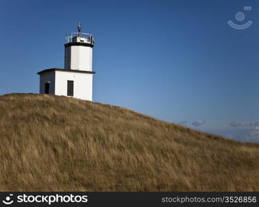 The lighthouse at Cattle Point is a local landmark on San Juan Island in Washington State. The small white structure is at the end of the island on top of a small hummock or hill.